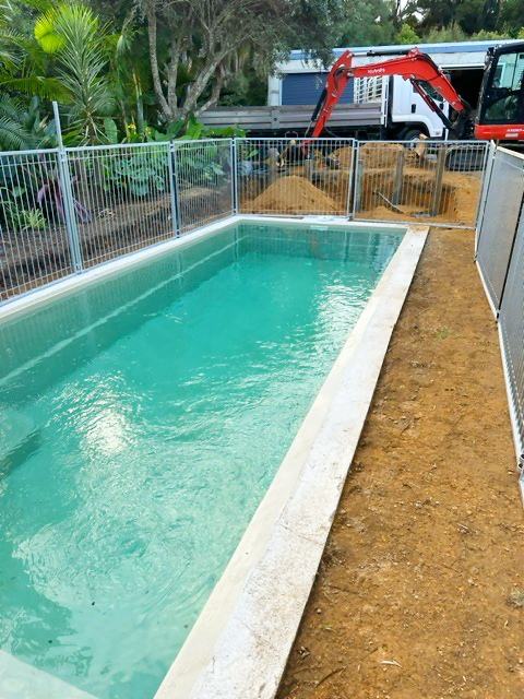 Finished green-blue fibreglass pool on site